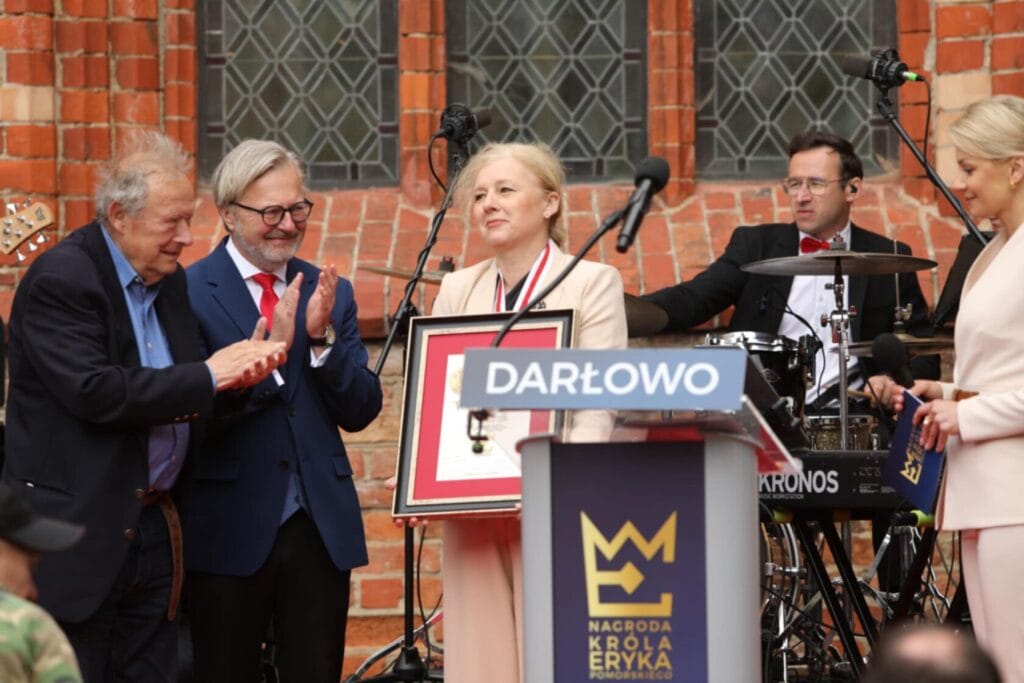 Ceremonia wręczenia nagrody w Darłowie, uczestnicy oklaskują.