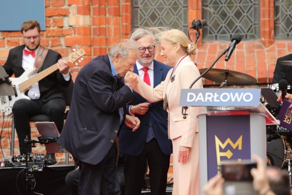 Starszy pan całuje rękę damy na ceremonii w Darłowie