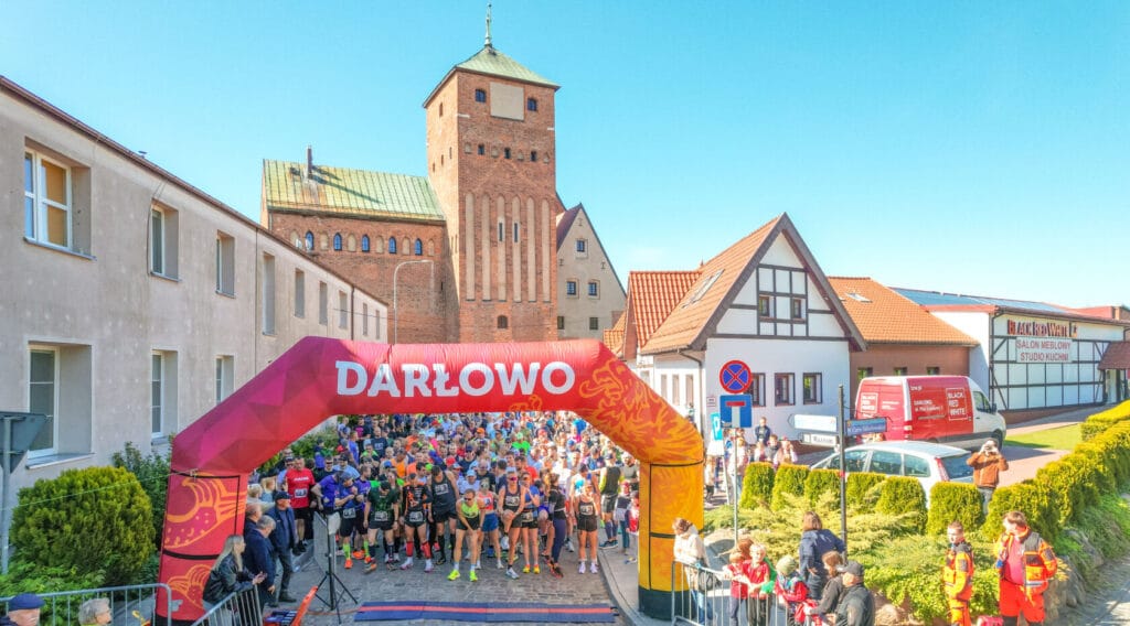 Maraton w Darłowie, biegacze przed startem, zabytkowy kościół