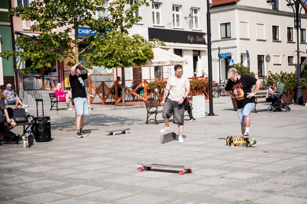 Ludzie jeżdżący na deskorolkach na miejskim placu