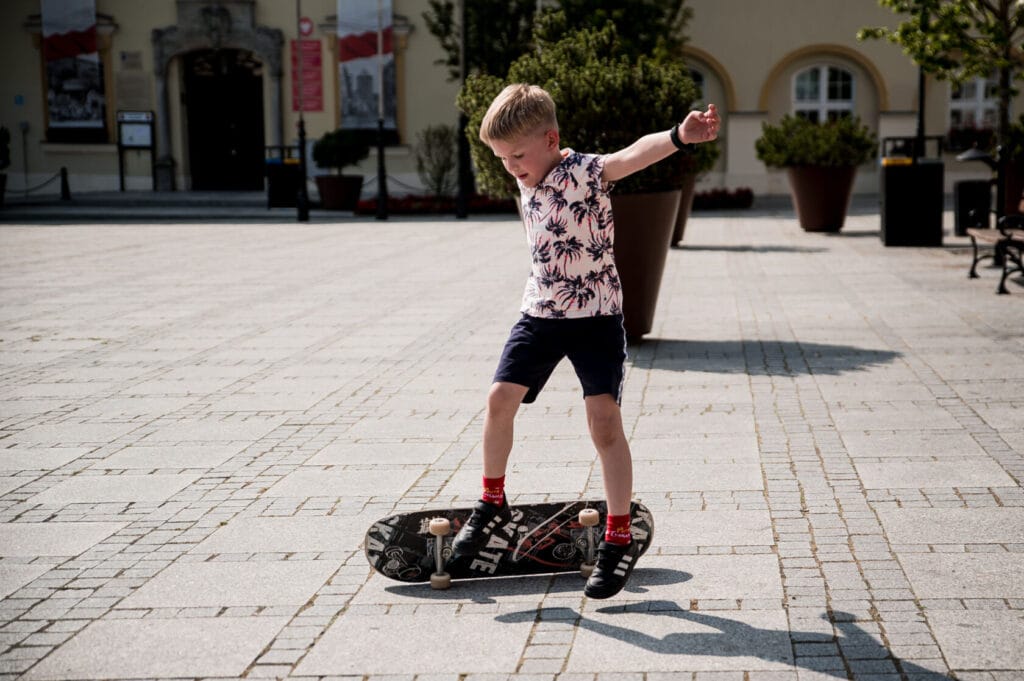 Chłopiec jeździ na deskorolce na miejskim placu