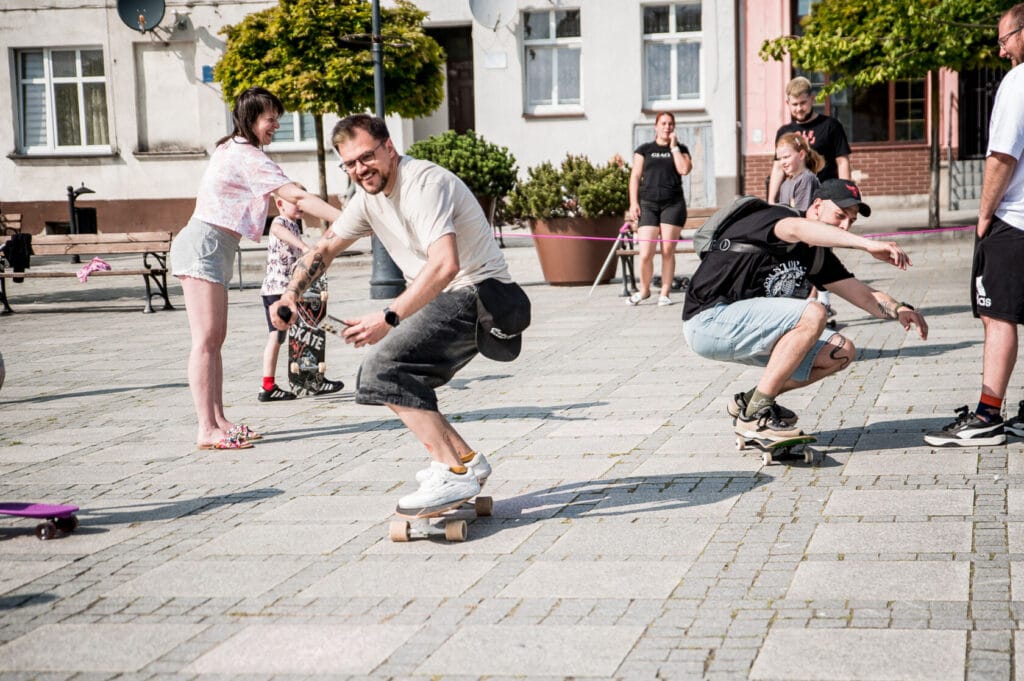 Rodzina uczy się jeździć na deskorolce na miejskim placu