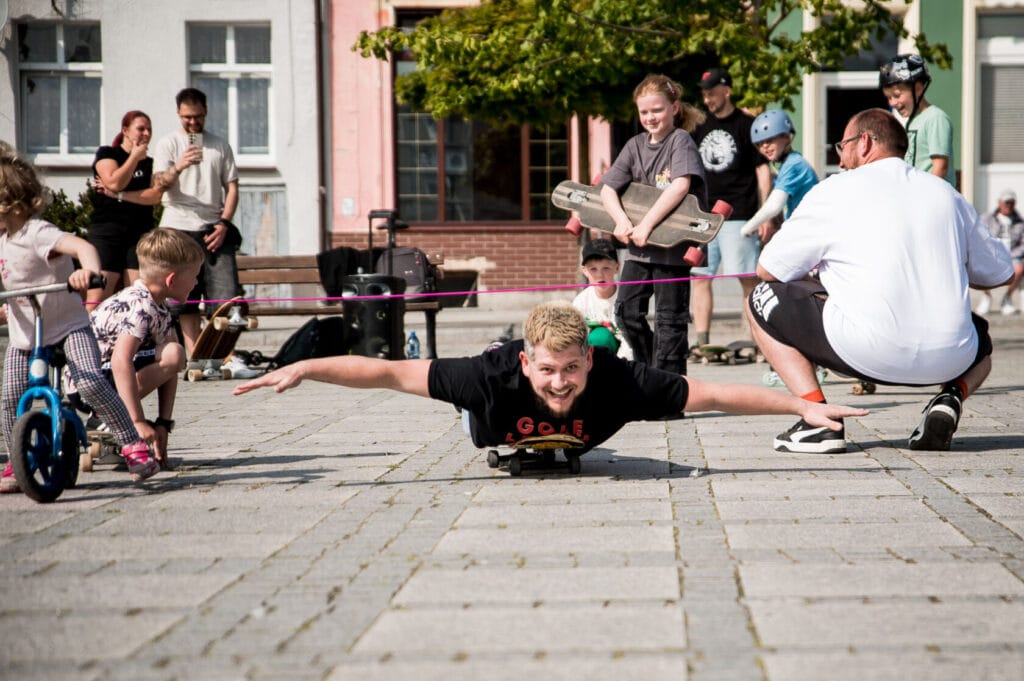 Mężczyzna jeżdżący na deskorolce leżąc na brzuchu