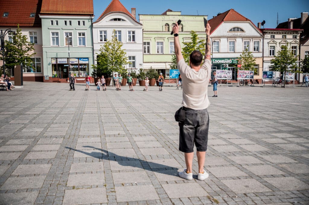 Mężczyzna macha rękami na miejskim placu