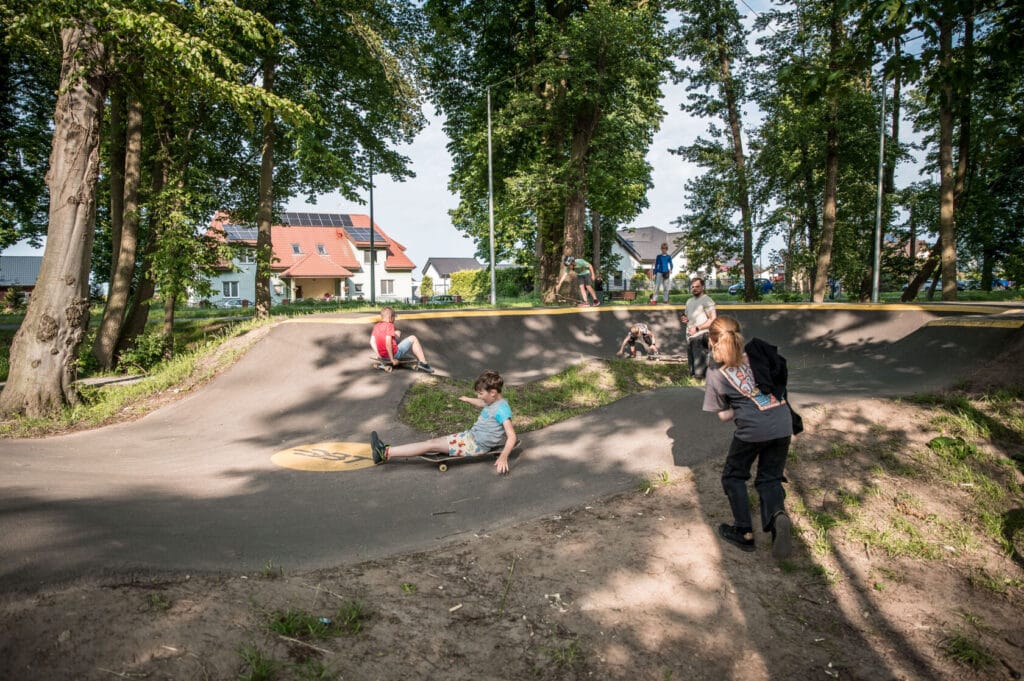 Dzieci bawiące się na miejskim skateparku w słoneczny dzień
