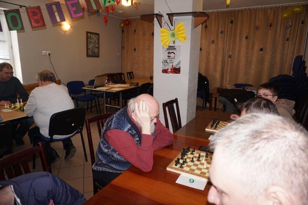 Ludzie grają w szachy w dekorowanej sali