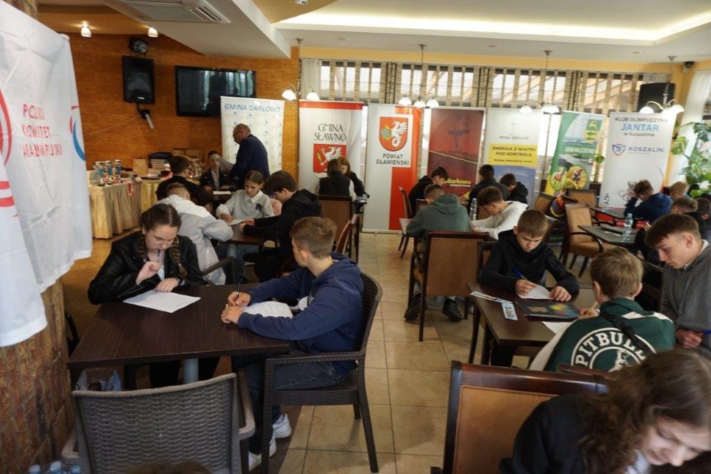 Uczniowie piszący na konkursie szkolnym w restauracji