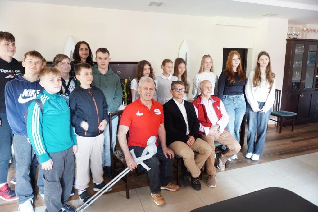 Grupa osób pozuje do zdjęcia w jasnym pokoju