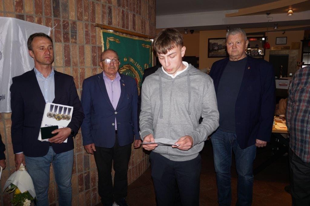 Młody mężczyzna czyta tekst na spotkaniu grupy