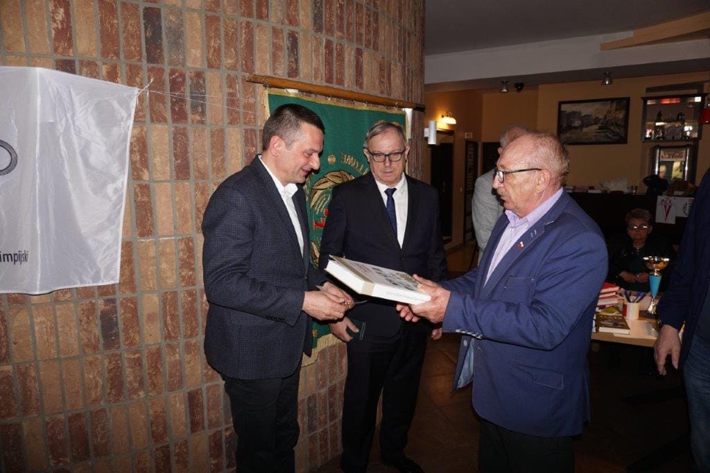 Trzej mężczyźni wymieniają książkę na ceremonii