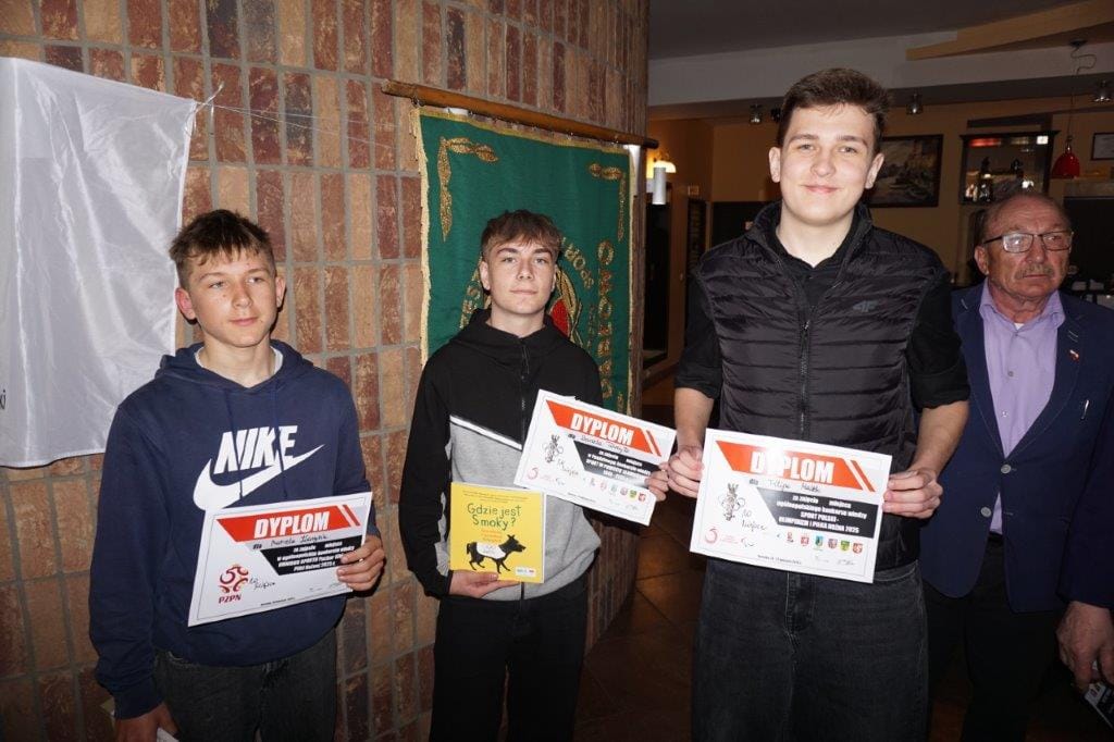 Trzej młodzi ludzie z dyplomami i starszy mężczyzna