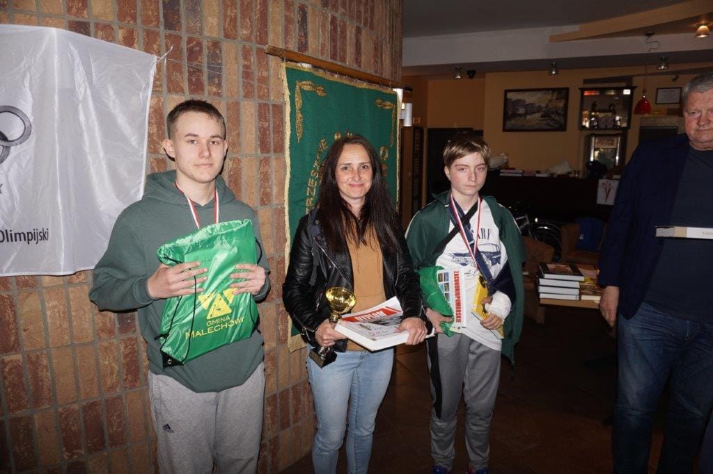 Trzej laureaci konkursu z nagrodami w pomieszczeniu