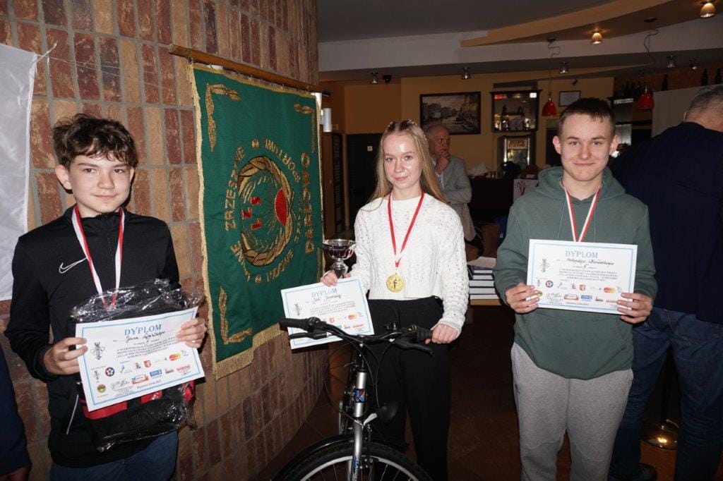 Młodzi laureaci z dyplomami i nagrodami w restauracji