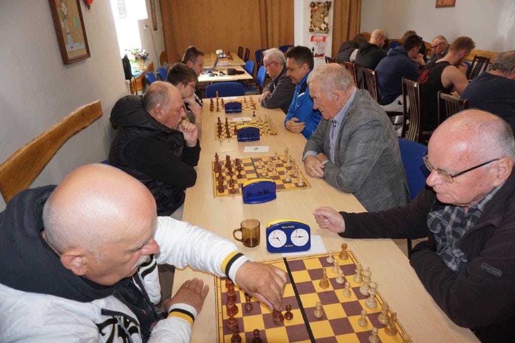 Starsi mężczyźni grają w szachy w klubie