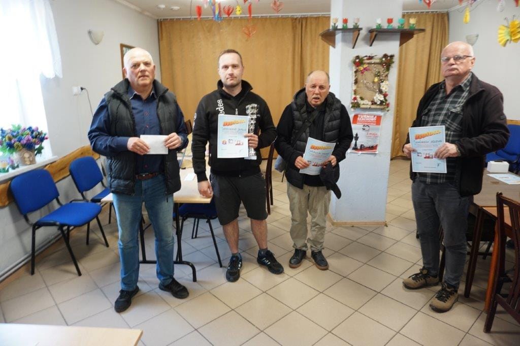 Czterech mężczyzn trzymających dyplomy w sali konferencyjnej