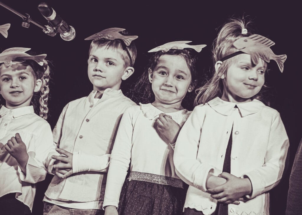 Dzieci w kostiumach z ptasimi przypinkami podczas przedstawienia