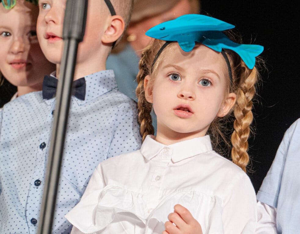 Dziewczynka z rybą na głowie podczas szkolnego występu
