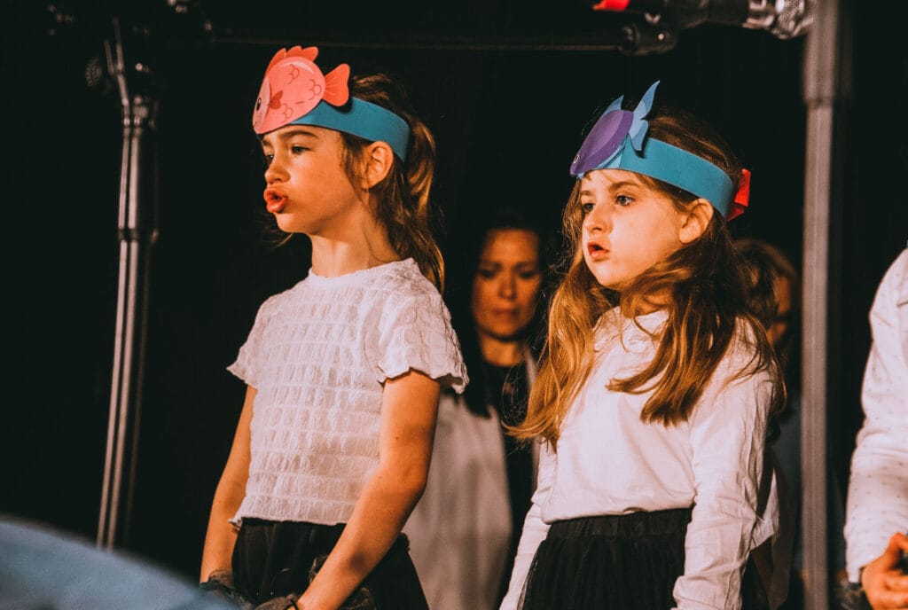 Dziewczynki w kostiumach zwierząt występują na scenie