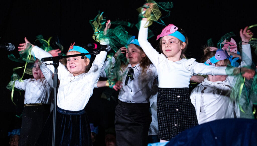 Dzieci prezentujące taniec z rybami na scenie