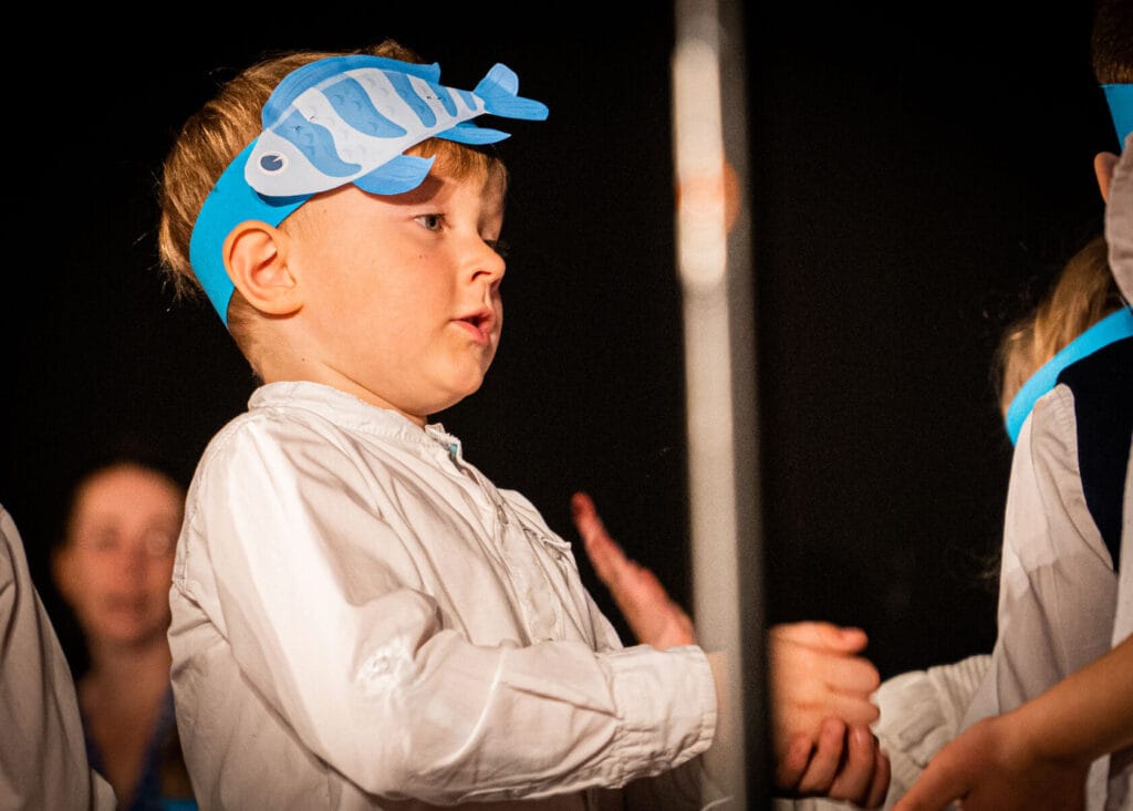 Chłopiec w błękitnej opasce ryby na przedstawieniu