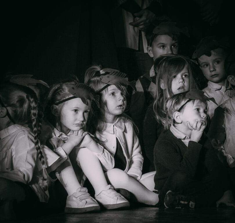 Dzieci w przedszkolu oglądają przedstawienie, czarno-białe zdjęcie