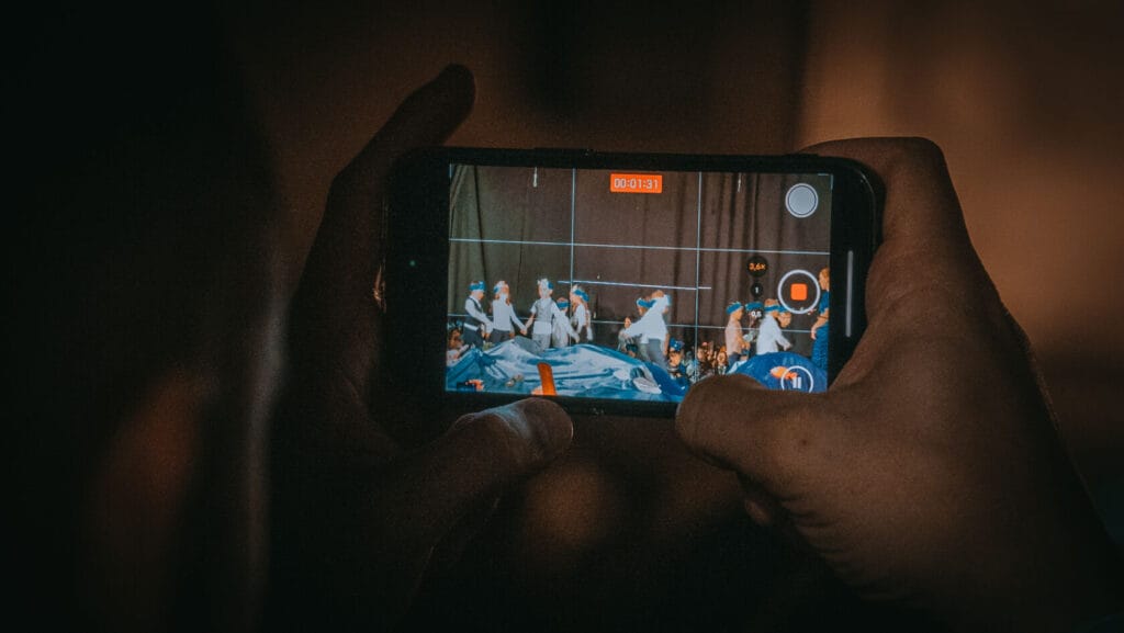 Osoba filmująca przedstawienie taneczne na smartfonie