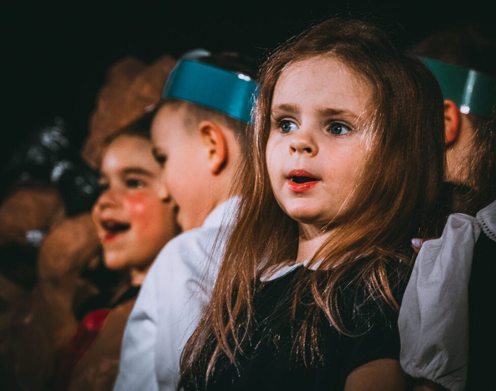 Dziewczynka z zaskoczonym wyrazem twarzy podczas przedstawienia