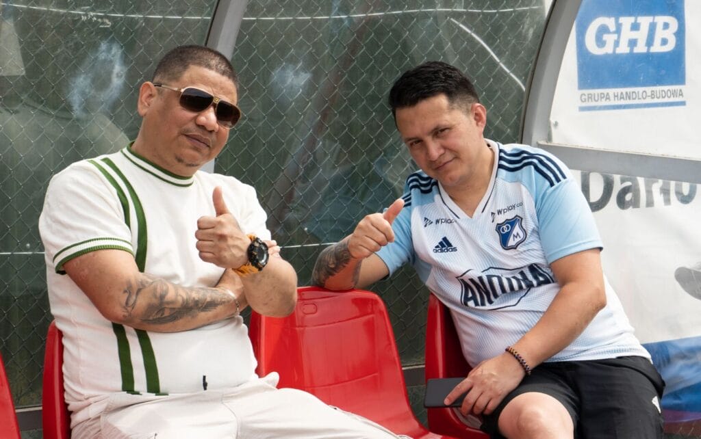 Dwaj mężczyźni siedzący, gestykulujący kciukami w górę