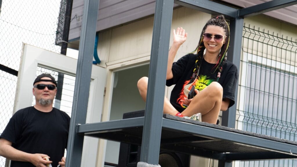 Kobieta macha siedząc na metalowej platformie