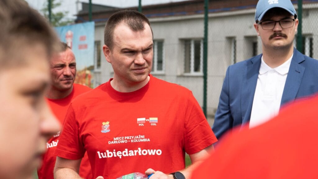 Mężczyźni w czerwonych koszulkach rozmawiają, sportowy kontekst