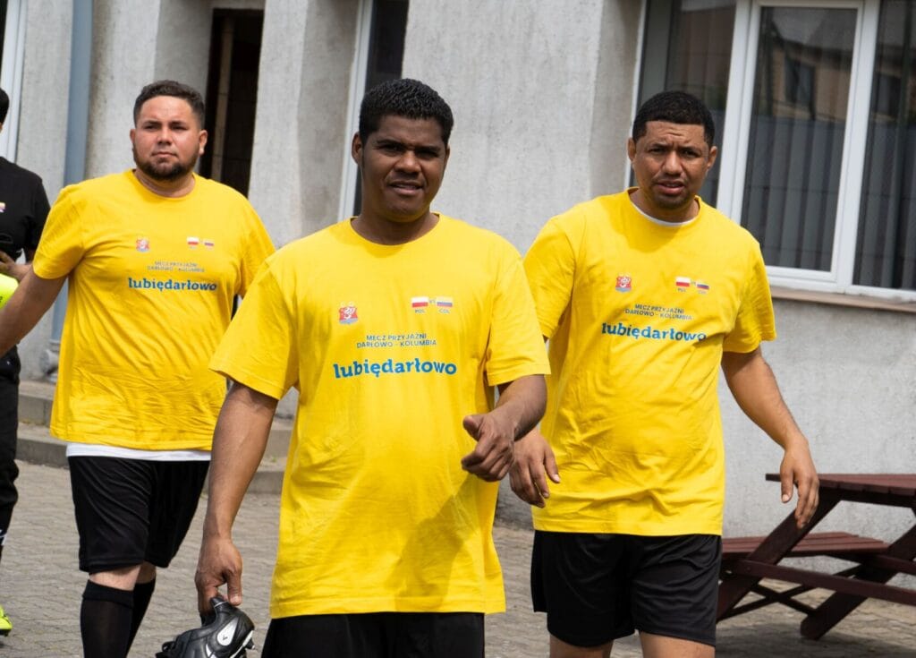 Mężczyźni w żółtych koszulkach idą na mecz piłki nożnej