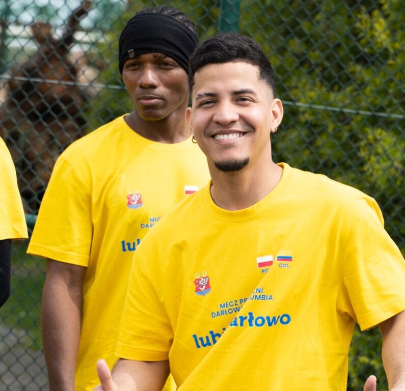 Dwóch uśmiechniętych mężczyzn w żółtych koszulkach