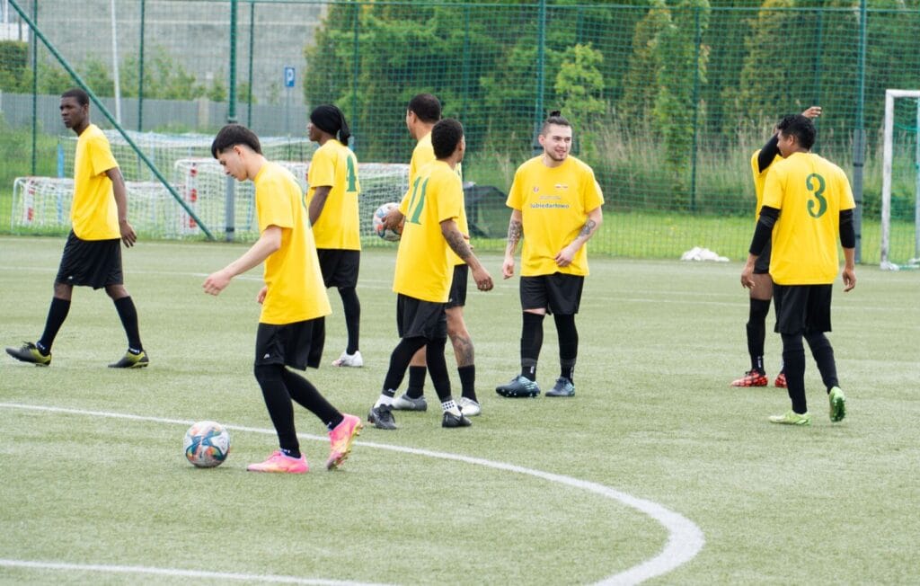 Gracze w żółtych koszulkach grają w piłkę nożną