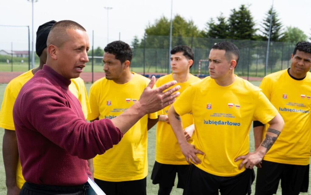 Trener omawia strategię z drużyną piłkarską na boisku