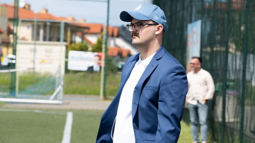 Mężczyzna w niebieskim garniturze i czapce na zewnątrz