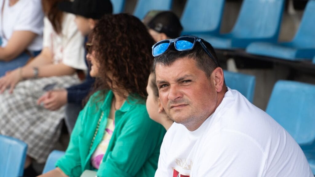 Mężczyzna i kobiety siedzą na trybunach stadionu