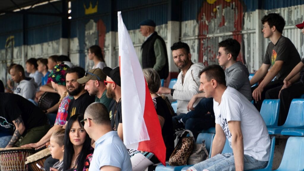 Widzowie z flagą na trybunach stadionu