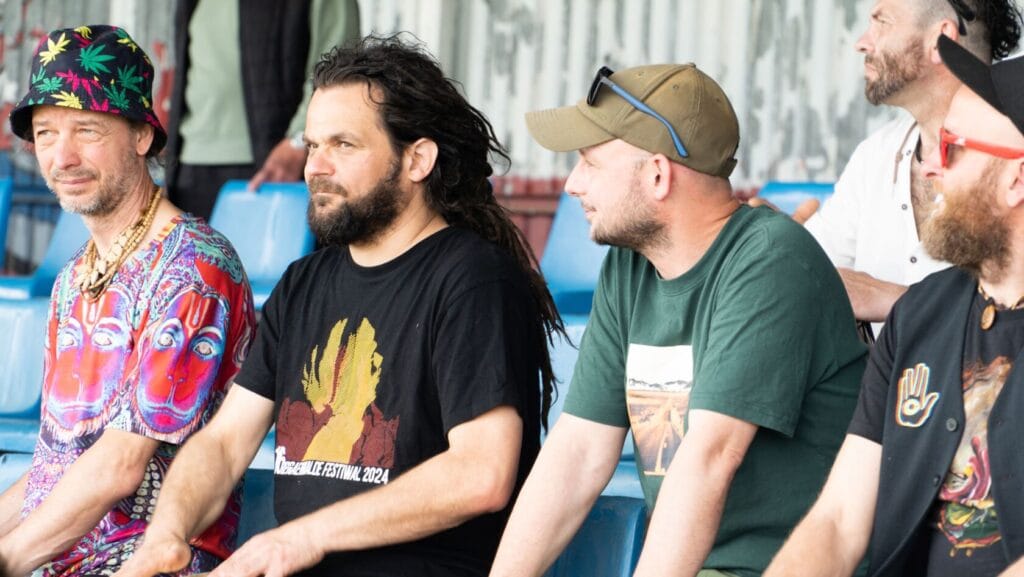 Mężczyźni siedzący na trybunach podczas wydarzenia kulturalnego