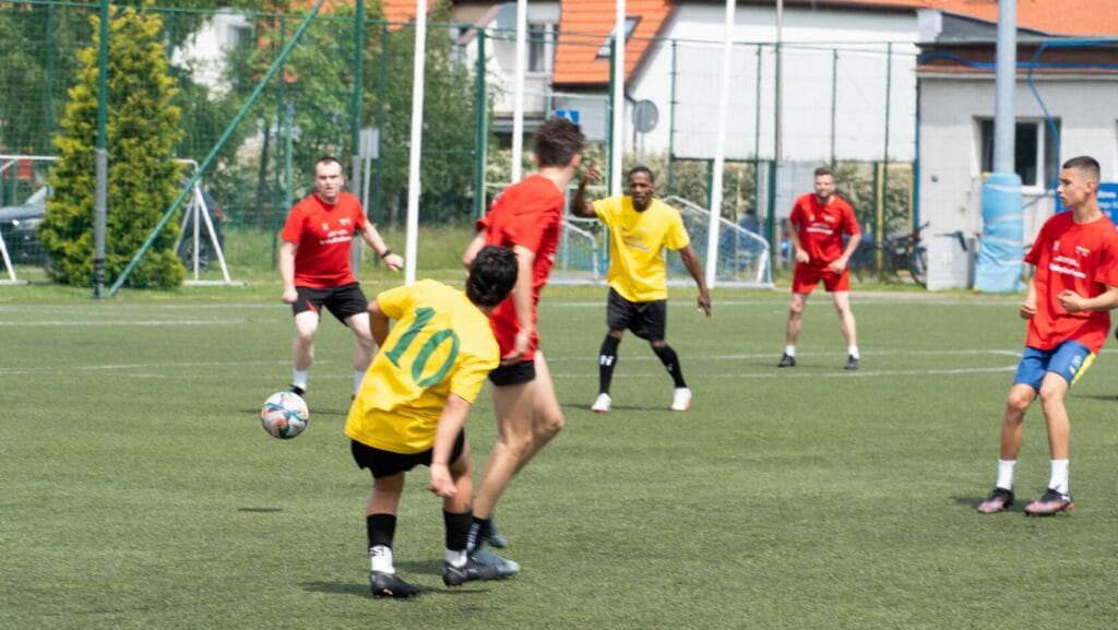 Młodzi mężczyźni grają w piłkę nożną na orliku