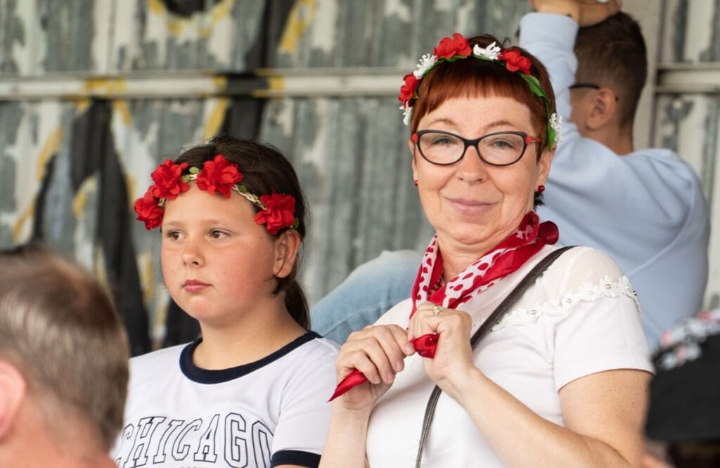 Starsza kobieta i dziewczynka w wiankach, ludowe stroje