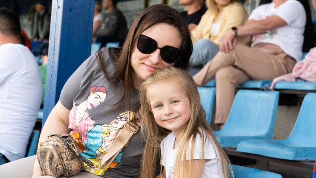 Kobieta i dziewczynka siedzą na trybunach stadionu