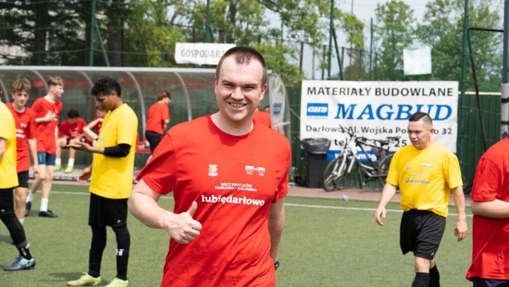 Uśmiechnięty mężczyzna w czerwonej koszulce na boisku