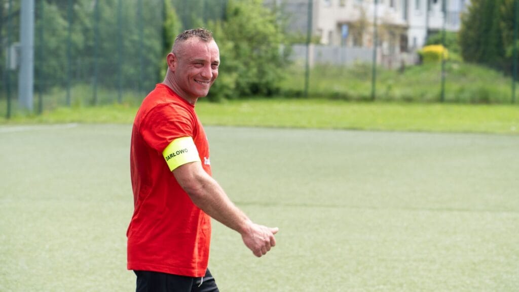 Mężczyzna w czerwonej koszulce na boisku