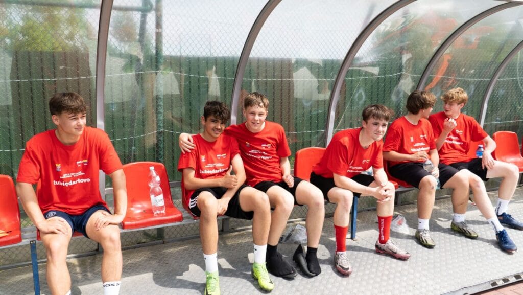 Młodzi piłkarze odpoczywają na ławce rezerwowych