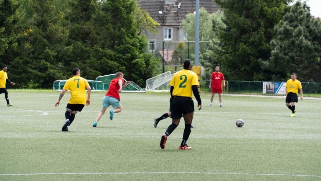 Mężczyźni grają w piłkę nożną na boisku sztucznym