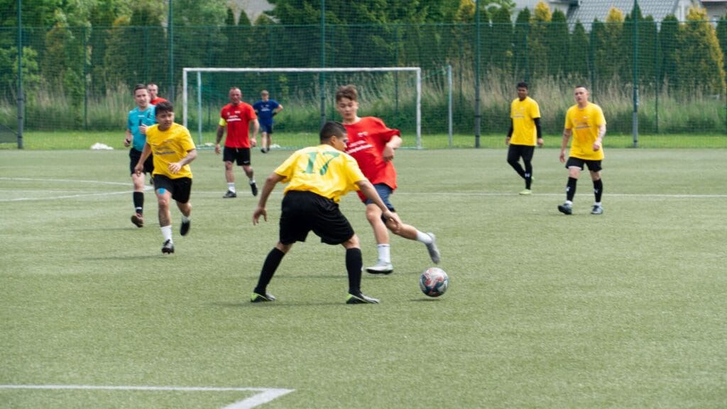 Mężczyźni grają w piłkę nożną na boisku trawiastym
