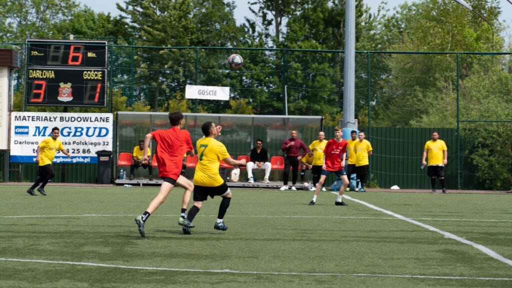 Mężczyźni grają w piłkę nożną na trawiastym boisku