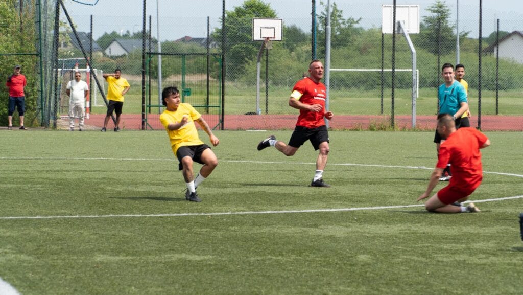 Ludzie grają w piłkę nożną na sztucznej murawie