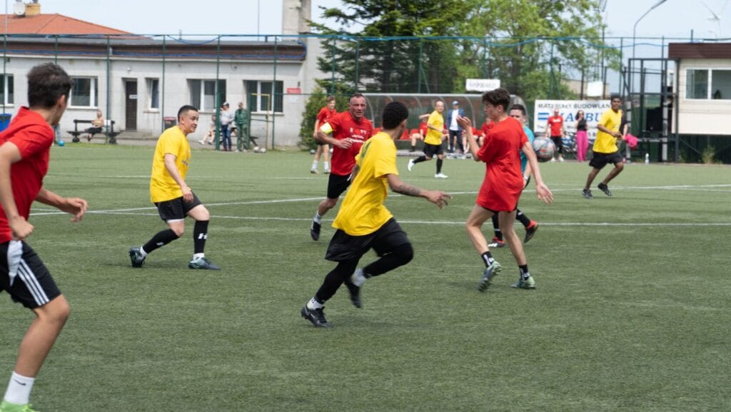 Młodzi mężczyźni grają w piłkę nożną na boisku