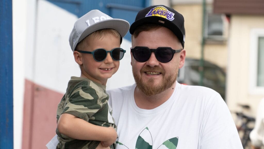 Młody chłopiec i mężczyzna w okularach słonecznych uśmiechają się